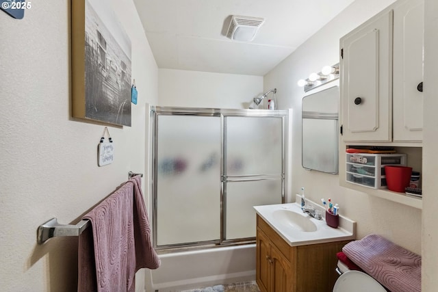 bathroom featuring bath / shower combo with glass door and vanity