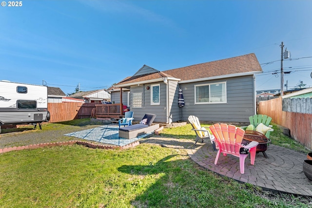 rear view of house with a patio, a lawn, and a fire pit