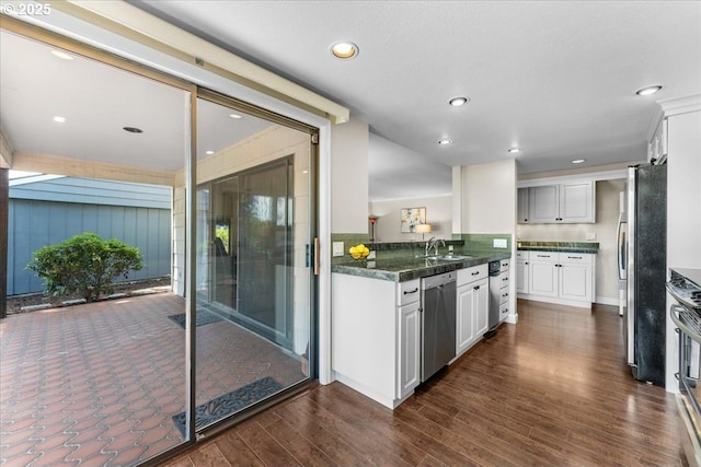 10620 SW Highland Dr, Portland, OR 97224 - kitchen with stainless steel appliances, white cabinetry, dark countertops, dark wood-style flooring, and recessed lighting