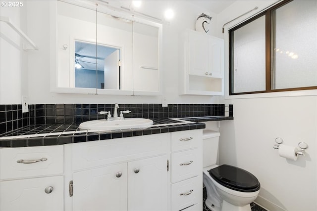12208 SE 38th Ave, Milwaukie, OR 97222 - half bathroom featuring vanity, toilet, baseboards, and tasteful backsplash