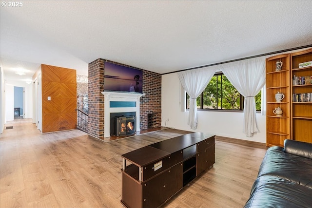 12208 SE 38th Ave, Milwaukie, OR 97222 - living area featuring light wood-style floors, a fireplace, and a textured ceiling