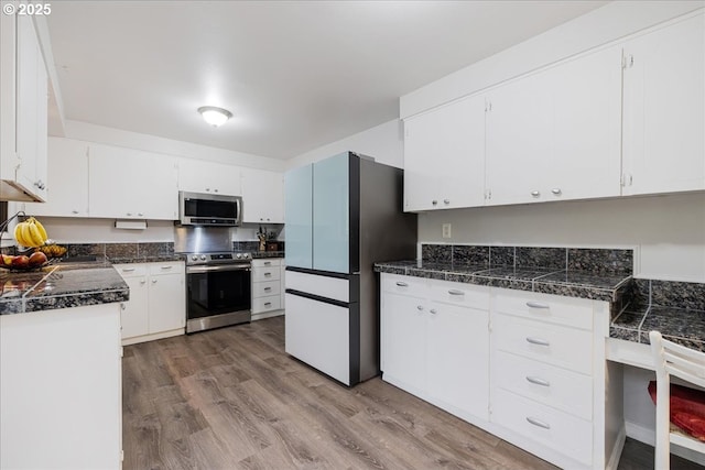 12208 SE 38th Ave, Milwaukie, OR 97222 - kitchen featuring stainless steel appliances, tile counters, light wood finished floors, and white cabinets