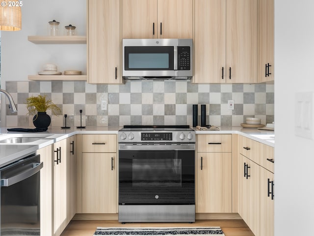 kitchen featuring sink, light brown cabinets, decorative backsplash, and appliances with stainless steel finishes