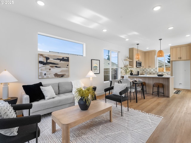 living room with sink and light hardwood / wood-style flooring