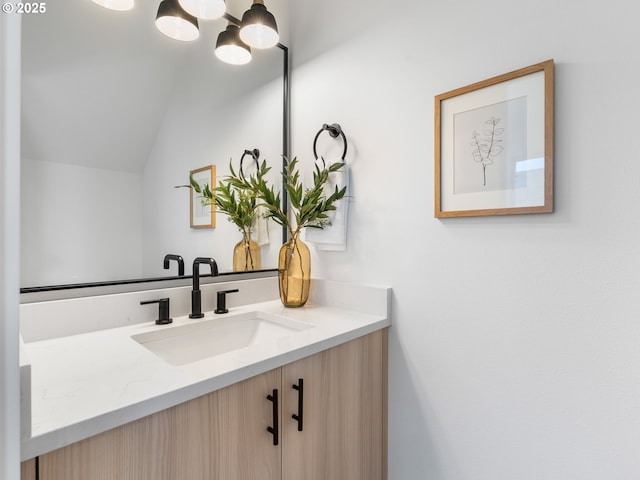 bathroom with vanity, a notable chandelier, and vaulted ceiling