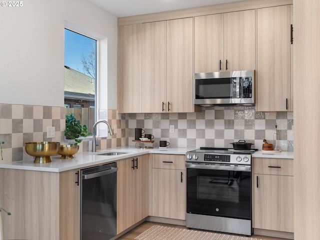 kitchen with light brown cabinetry, sink, backsplash, and appliances with stainless steel finishes