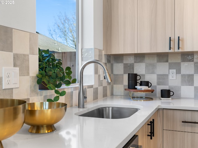 kitchen featuring light brown cabinetry, sink, and tasteful backsplash