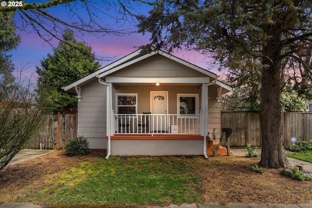 bungalow-style house featuring fence and covered porch