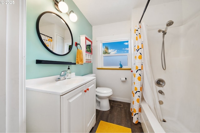 bathroom featuring vanity, wood finished floors, visible vents, shower / bath combo with shower curtain, and toilet