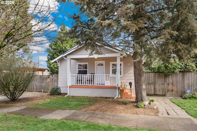 bungalow with covered porch and fence