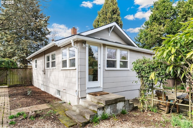 view of outdoor structure with entry steps and fence