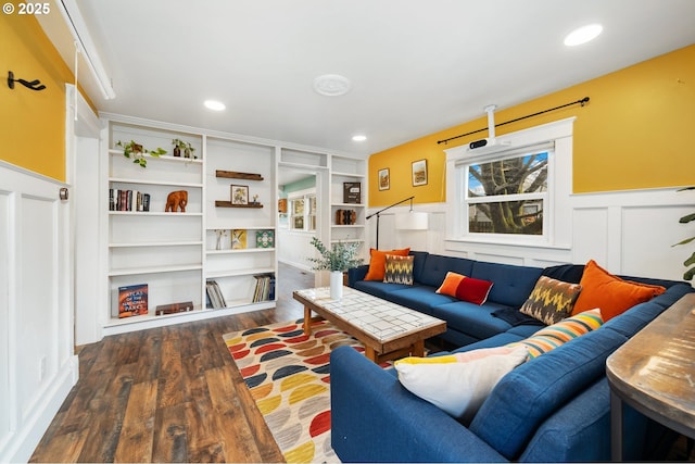 living area with recessed lighting, built in shelves, wood finished floors, and wainscoting