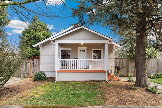 bungalow-style home with a porch and fence