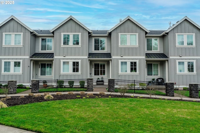 view of front of property featuring board and batten siding, a standing seam roof, and fence