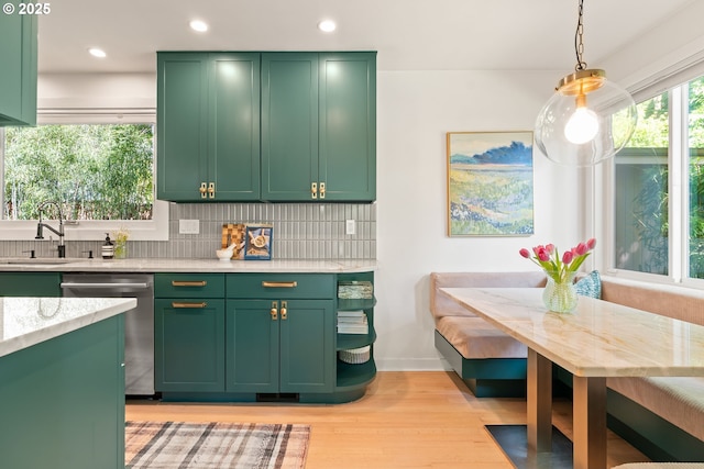 5431 SW Alfred St, Portland, OR 97219 - kitchen with green cabinets, stainless steel dishwasher, breakfast area, a sink, and light wood-style floors