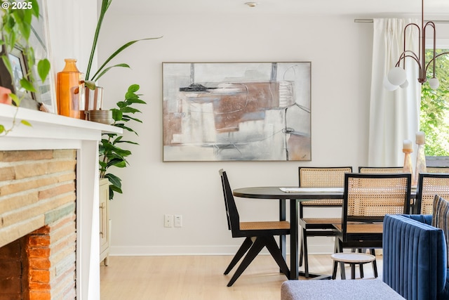 5431 SW Alfred St, Portland, OR 97219 - dining area featuring a brick fireplace, wood finished floors, and baseboards