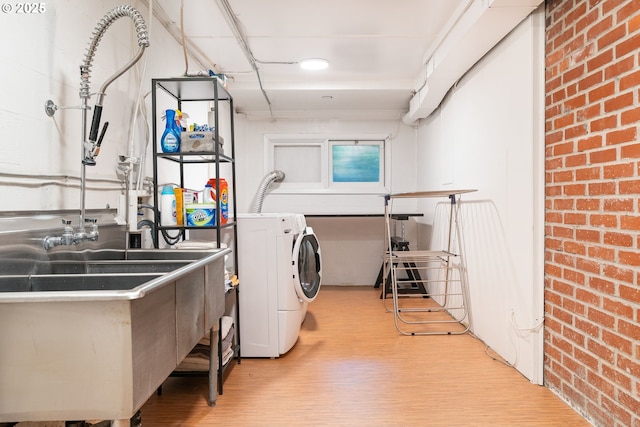 5431 SW Alfred St, Portland, OR 97219 - laundry area with washing machine and dryer, brick wall, and light wood finished floors