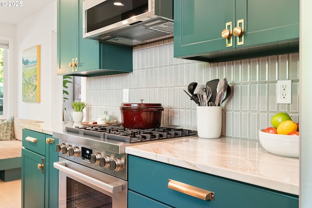 5431 SW Alfred St, Portland, OR 97219 - kitchen featuring appliances with stainless steel finishes, green cabinets, backsplash, and light stone countertops