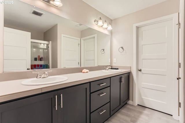 bathroom with vanity and a shower with door