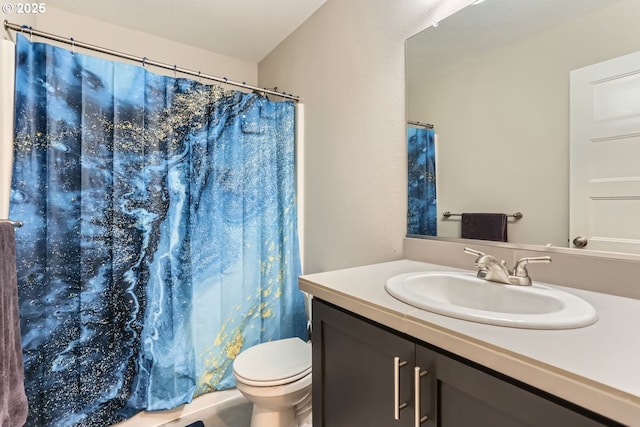 bathroom featuring vanity, toilet, and a textured ceiling