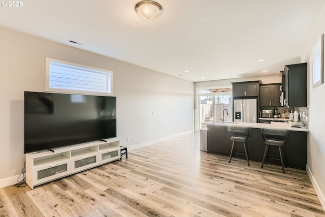 living room with sink and light hardwood / wood-style floors