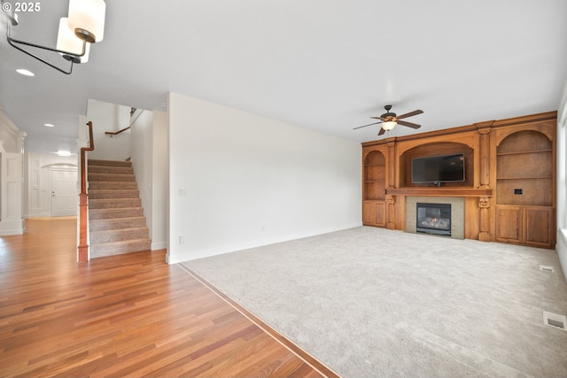 2530 NW 22nd Ave, Camas, WA 98607 - unfurnished living room featuring ceiling fan, a tiled fireplace, stairs, recessed lighting, and light wood-style floors
