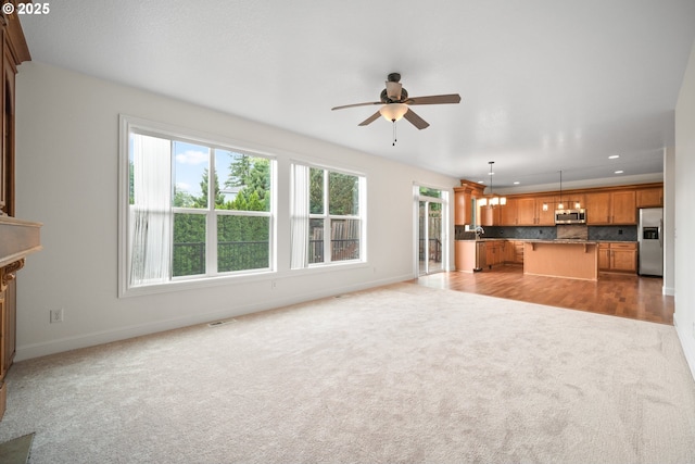 2530 NW 22nd Ave, Camas, WA 98607 - unfurnished living room with light carpet, a ceiling fan, baseboards, recessed lighting, and a chandelier