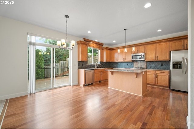 2530 NW 22nd Ave, Camas, WA 98607 - kitchen with stainless steel appliances, wood finished floors, a chandelier, decorative backsplash, and recessed lighting
