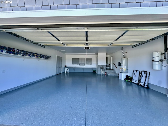 98694 Woodriff Ln, Brookings, OR 97415 - garage featuring water heater, baseboards, and a garage door opener
