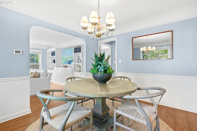 6611 SE 40th Ave, Portland, OR 97202 - dining space with a chandelier, wood finished floors, arched walkways, and crown molding