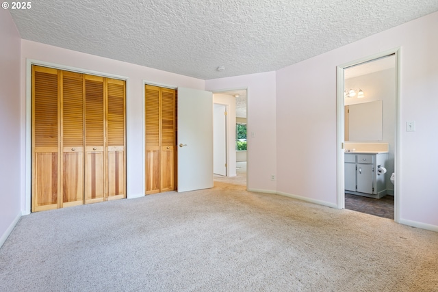 6120 SW Cross Creek Dr, Beaverton, OR 97078 - unfurnished bedroom featuring two closets, carpet flooring, ensuite bathroom, and a textured ceiling