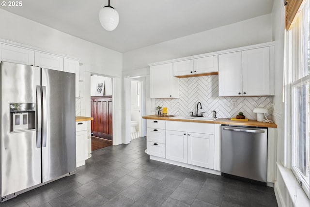 5025 NE 6th Ave, Portland, OR 97211 - kitchen with stainless steel appliances, wooden counters, a sink, and decorative backsplash