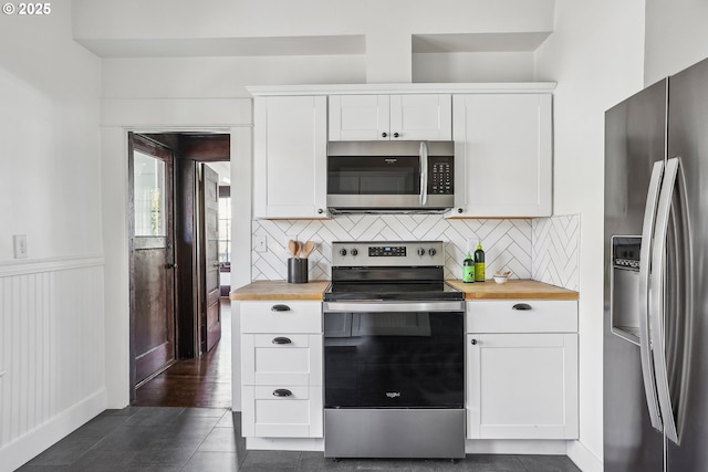 5025 NE 6th Ave, Portland, OR 97211 - kitchen featuring stainless steel appliances, wooden counters, tasteful backsplash, white cabinetry, and a wainscoted wall