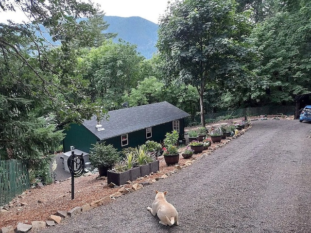 exterior space featuring a garden, fence, and a mountain view