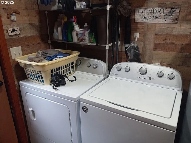 laundry area featuring laundry area, wooden walls, and washing machine and clothes dryer