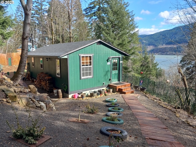 view of outbuilding with an outdoor structure, fence, and a mountain view