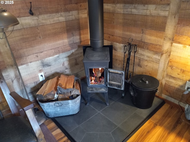 room details with a wood stove, wood walls, and wood finished floors