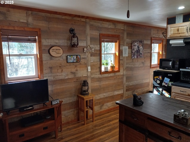 interior space featuring black microwave, ventilation hood, dark wood finished floors, and wooden walls