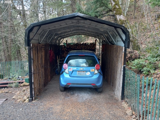 view of vehicle parking with a detached carport and fence