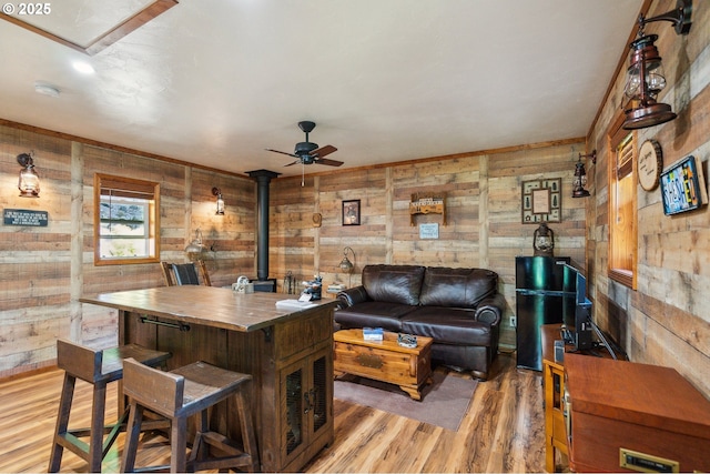 241 Jackson Rd, Cook, WA 98605 - living room with a wood stove, a ceiling fan, light wood-style flooring, and wood walls