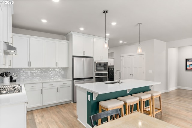 kitchen featuring pendant lighting, sink, and a kitchen island with sink