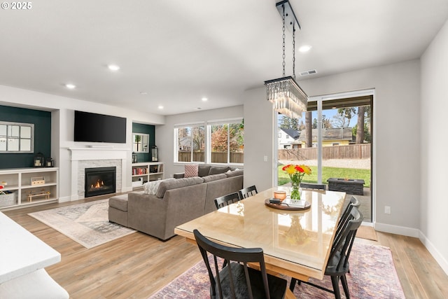 dining area with a fireplace and light hardwood / wood-style flooring