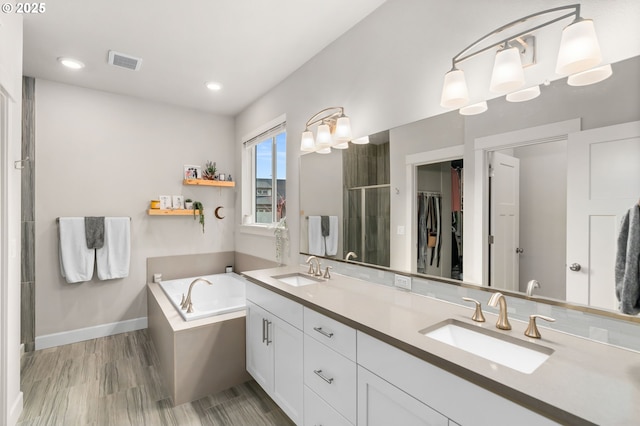 bathroom with vanity, hardwood / wood-style flooring, and separate shower and tub