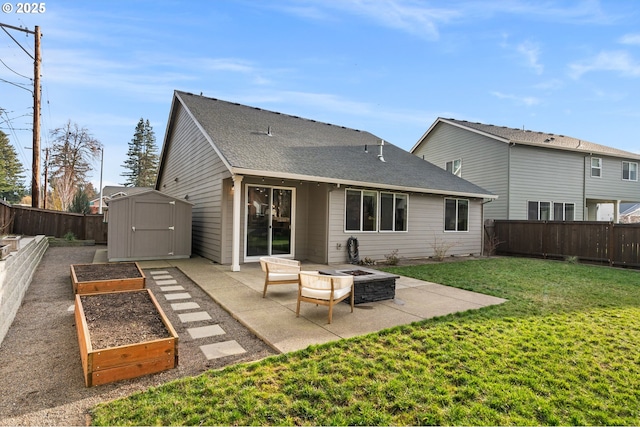 rear view of property featuring an outdoor fire pit, a patio area, a shed, and a lawn