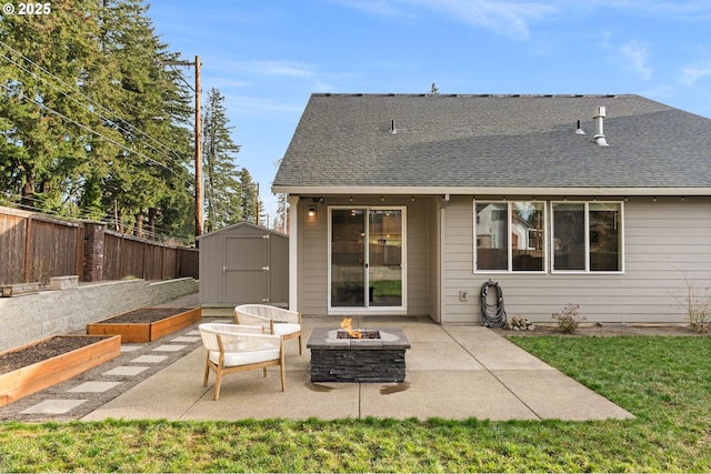 rear view of house with a storage shed, a patio, and a fire pit