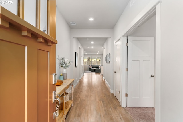 hallway with light hardwood / wood-style floors