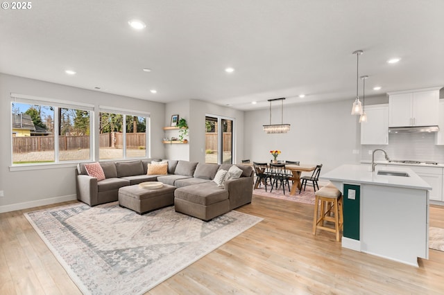 living room with sink and light hardwood / wood-style flooring