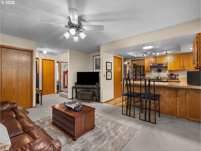 67 NW Orchard Pl, Gresham, OR 97030 - living room featuring a textured ceiling, ceiling fan, and light carpet