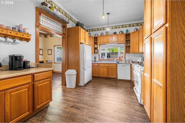 kitchen featuring white appliances, brown cabinetry, an ornate ceiling, hanging light fixtures, and a sink