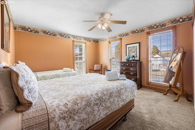 carpeted bedroom with a ceiling fan and baseboards